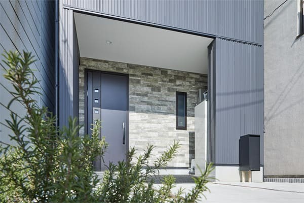 石とガルバリウムを使用した3階建ての家